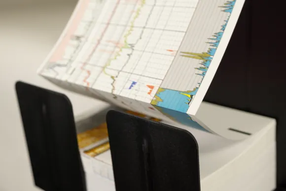 A printed color well log folding out of the printer onto a stack of fan-fold paper